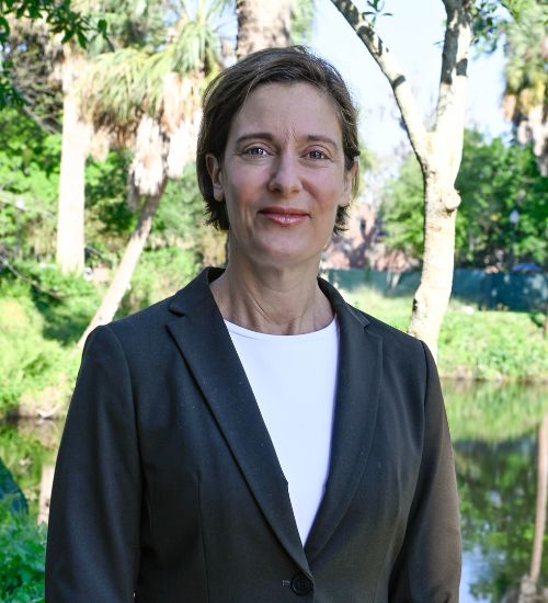 Dr. Fogarty smiles in front of a tree.