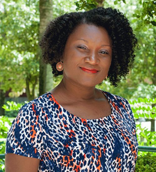 Dr. LaToya ONeal smiles in front of trees.