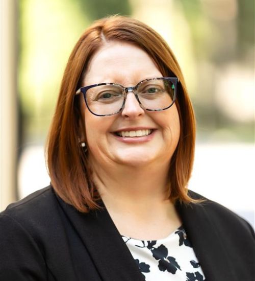 Dr. Gillen smiles in front of a blurred background.