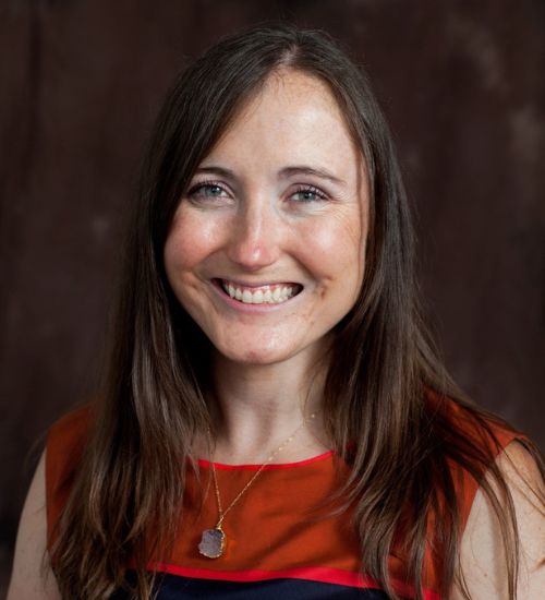 Dr. Michelle Abraczinskas smiles in front of a dark backdrop.