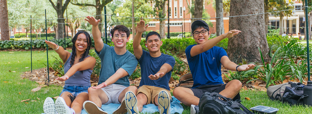 Students in a field doing the UF Chomp
