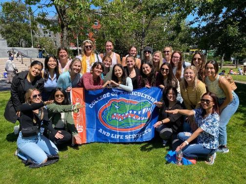 A group of students standing around a UF College of Agricultural and Life Sciences flag.